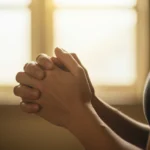 Mãos em oração, simbolizando a busca sincera por amor e conexão espiritual.