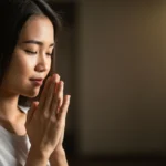 Mãos em oração com luz suave, simbolizando gratidão e conexão espiritual.