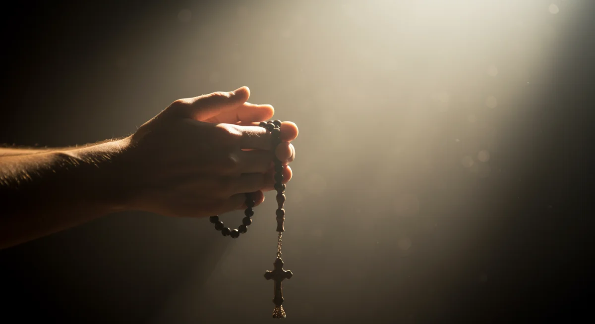 Mãos segurando um terço em oração, transmitindo devoção e busca por paz interior.