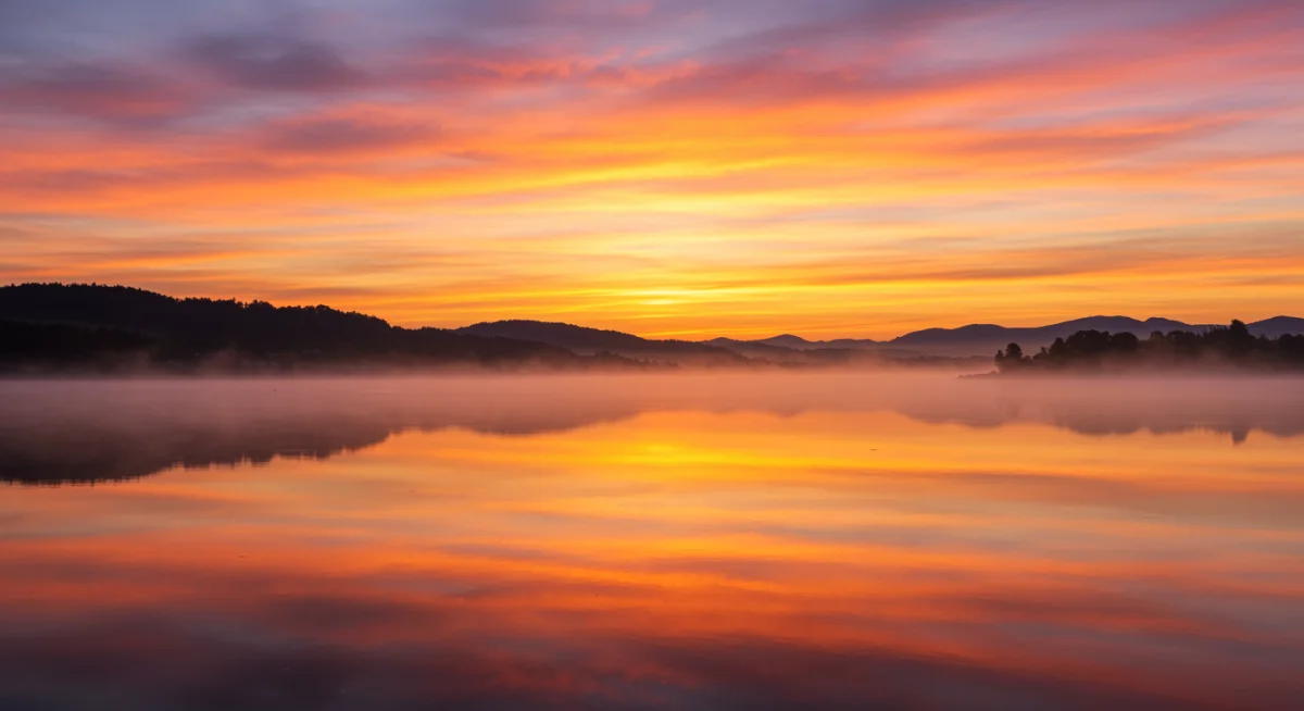Nascer do sol sobre uma paisagem calma, simbolizando a esperança e um novo começo encontrados em Deus.