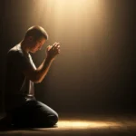 Pessoa orando de joelhos, mãos unidas, com luz divina, simbolizando fé e conexão espiritual.