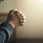 Pessoa orando urgentemente com as mãos postas, buscando uma resposta divina.